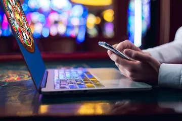 A woman smiling by bright slot machines showing lucky symbols, showcasing the exciting slot offerings at 0777DET.